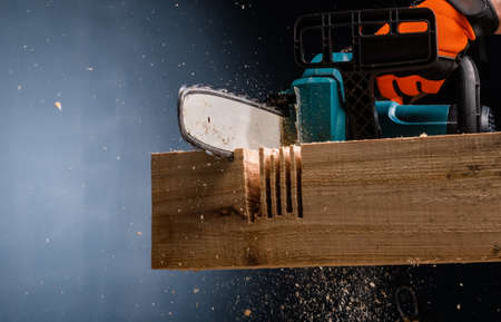 Modern electric chain  saw in the workshop cutting woodの写真素材