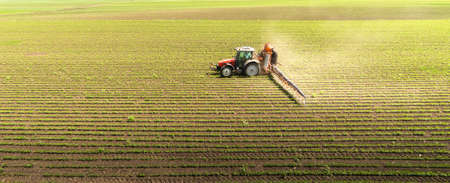 Tractor spraying pesticides on soybean field  with sprayer at spring