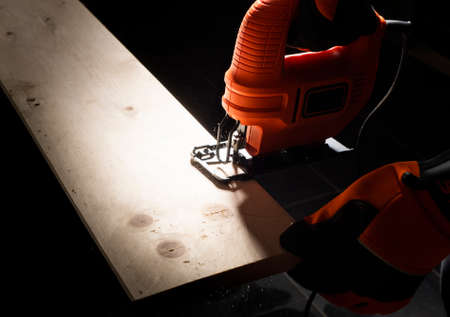 A carpenter worknig with jig saw and wood