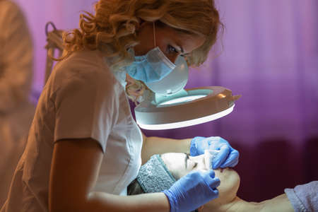 Face Treatment. Woman in Beauty Salon Gets Marine Mask