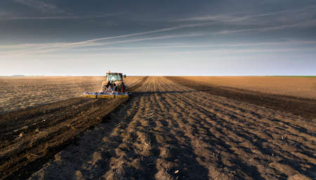 Farmer preparing his field in a tractor ready for spring.