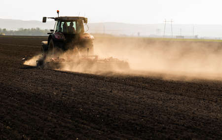 Farmer preparing his field in a tractor ready for spring.の写真素材