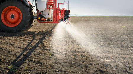 Tractor spraying pesticides on field  with sprayer 