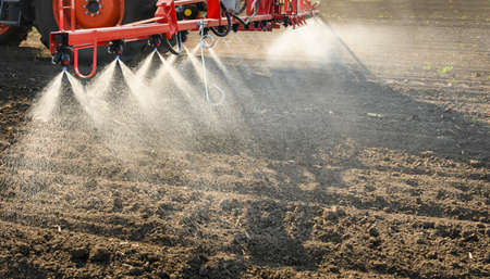 Tractor spraying pesticides on field  with sprayer 