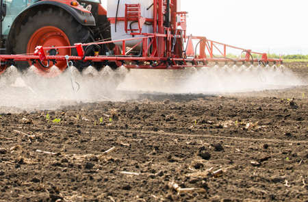 Tractor spraying pesticides on field  with sprayer