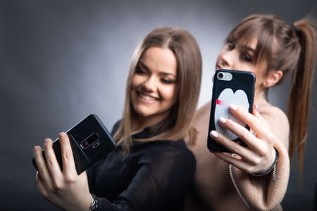 Teenage Girls Taking Selfie On Mobile Phone in studioの写真素材