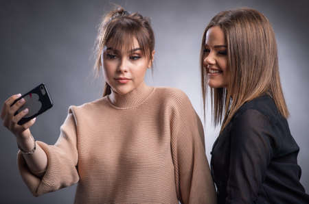 Teenage Girls Taking Selfie On Mobile Phone in studioの写真素材