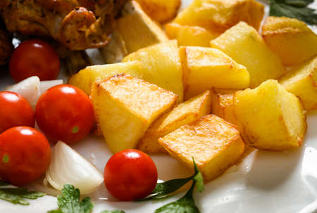 Closeup of seasoned roast potatoes and vegetables