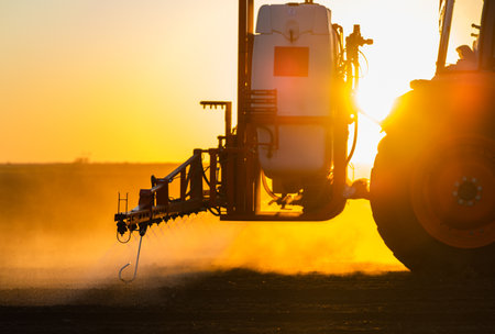 Tractor spraying pesticides on field  with sprayer