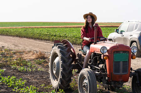 Female farmer driving a tractor in field