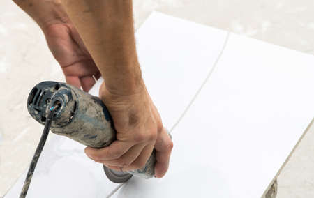 Close-up of worker cutting stone with grinder.
