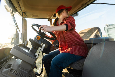 Girl farmer drives a tractor. Agricultural machineの写真素材