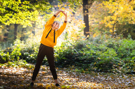 girl exercise in the autumn forestの写真素材