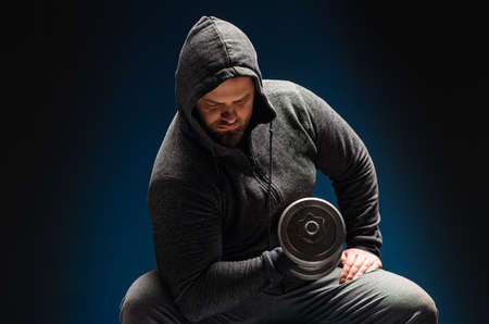 Healthy man hard workout of biceps in gym