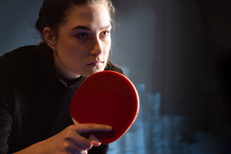 Young girl plays table tennis closeup