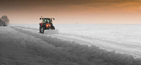tractor cleans road from snow in the winter