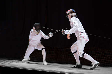 Fencer woman with fencing sword. Fencers duel concept