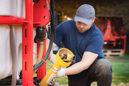 The farmer repairs agricultural machines in field