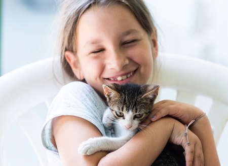 Little girl holding baby cat. Kids and petsの写真素材