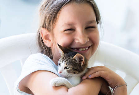 Little girl holding baby cat. Kids and petsの写真素材