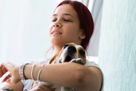 A happy girl holding her little dog