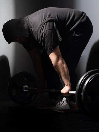 Fit young man lifting weights in a gym