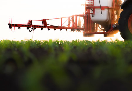 Tractor spraying pesticides on corn field  with sprayer at springの写真素材