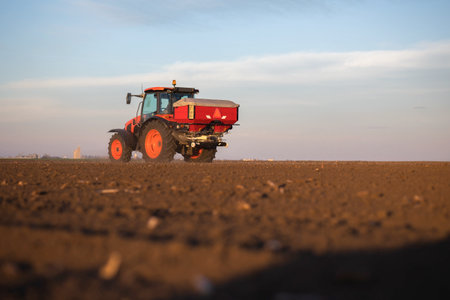 Tractor spreading artificial fertilizers. Transport, agricultural.の写真素材