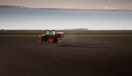 Tractor spreading artificial fertilizers. Transport, agricultural.の写真素材