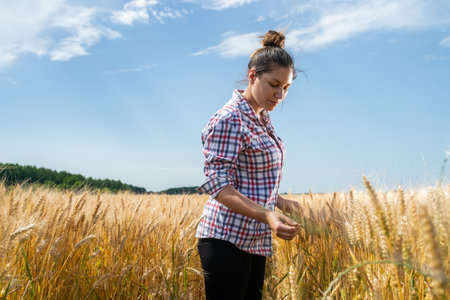 Woman farmer in a field of wheat. Growth, outdoor.