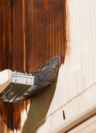 Maintaining of wooden surfaces with fresh protective paint.の写真素材