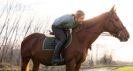Young woman taking care of her horse, outside.の写真素材