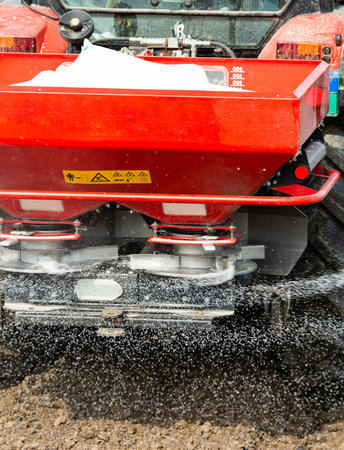 Tractor spreading artificial fertilizers  in field
