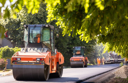 Machines are crushing the asphalt after pouring to make road