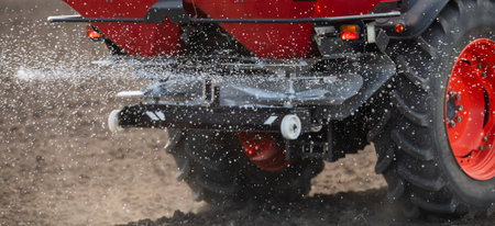 Tractor spreading artificial fertilizers  in field