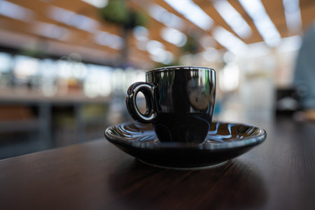 One cup of unfinished coffee stands on a wooden table in restaurantの写真素材