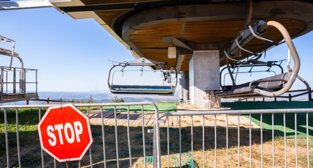 Ski resort, cable car gondola during summer. Sunny day on the mountain with sign stop.