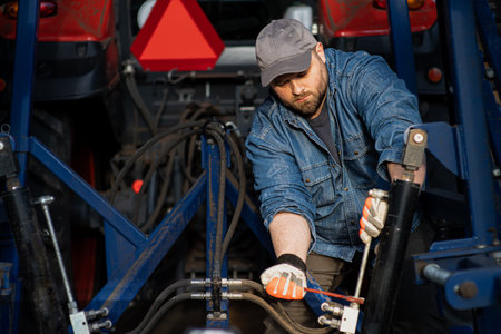The farmer repairs agricultural machines in fieldの写真素材