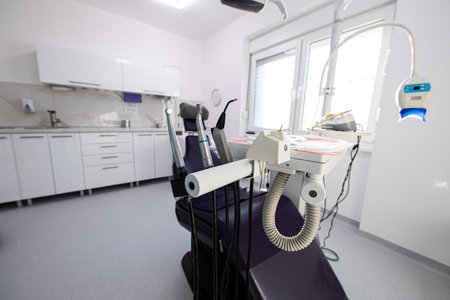 White dental office with tools ready to work and a black dental chairの写真素材
