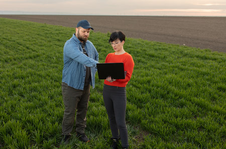 Women agronomist and farmer checks the quality wheat in field.の写真素材