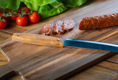 Dried sliced pork sausage on a cutting board. Top view.