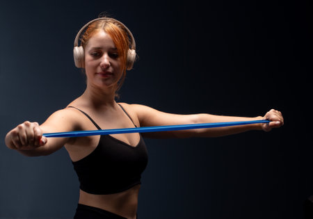 Woman in black sports clothes exercising with resistance band in studio. Resistance Band Workout For...