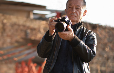 Happy senior man taking photographs with a digital camera whileの写真素材