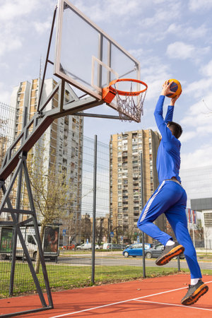 Sportsmen playing game of basketball at outdoor court, empty space.