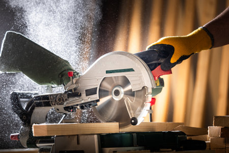 Close-up of a carpenter using a circular saw to cut a large board of woodの写真素材
