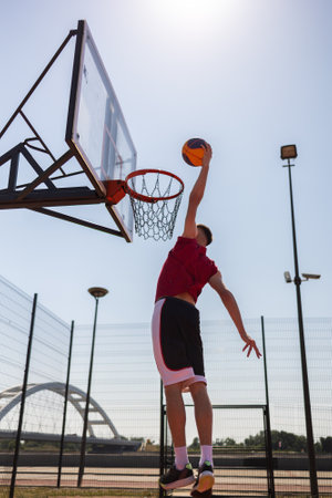 Sportmen playing game of basketball at outdoor court, empty space.sity