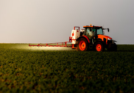 Tractor spraying pesticides on soybean field  with sprayer at springの写真素材