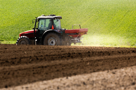 Tractor spreading artificial fertilizers. Transport, agricultural.の写真素材