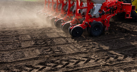 Farmer with tractor seeding - sowing crops at agricultural field. Plants, wheat.の写真素材