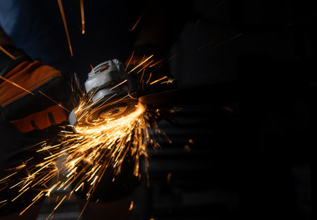Industrial worker with an angle grinder at the factory, Grinding Metal
